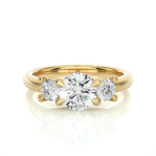 Front view of 2 Carat Round Moissanite Three Stone Engagement Ring In Yellow Gold, highlighting the brilliant center moissanite stone.