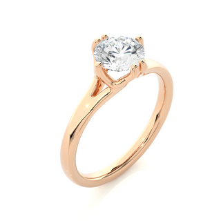 Angled view of 1 Carat Round Moissanite Split Shank Solitaire Engagement Ring In Rose Gold, showcasing the band and setting.
