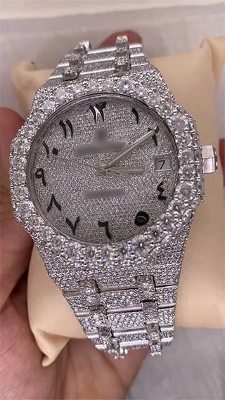 Front view of a cheap moissanite replica watch with Arabic numerals, date display, and full pavé stone dial and band.
