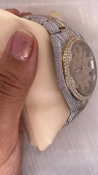 Side view of a moissanite watch with a gold-tone dial, stone-studded bezel and case, and detailed metal strap design.