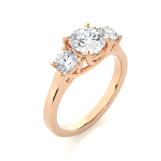 Angled view of 1.50 Ct Round Moissanite Three Stone Engagement Ring In Rose Gold, showcasing the band and setting.​