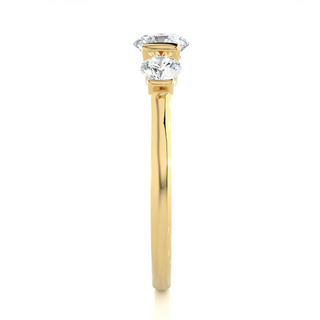 Side profile of 2 Carat Round Cut Moissanite Three Stone Engagement Ring In Yellow Gold, highlighting the brilliant center moissanite stone., highlighting the prong setting.